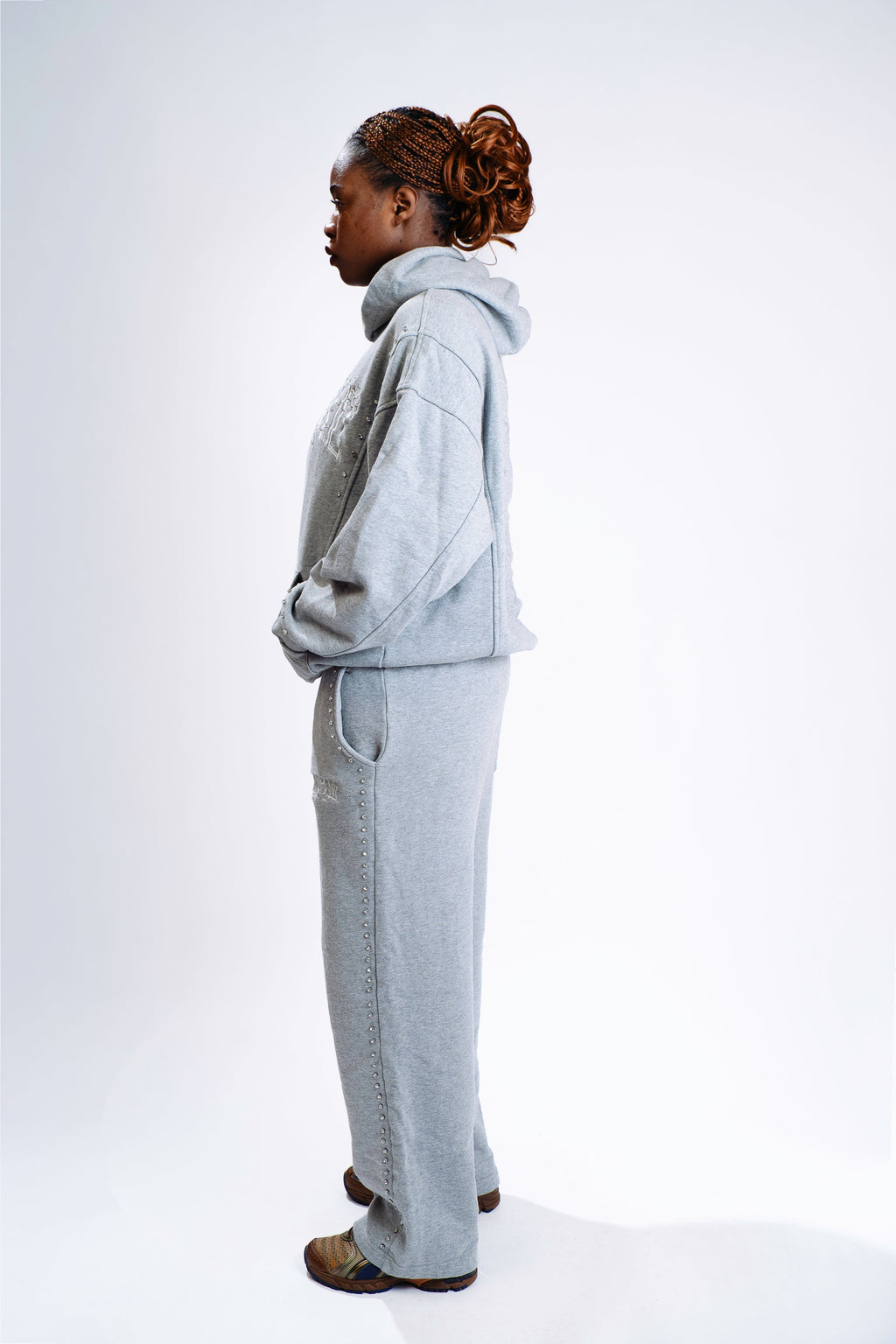 Model wearing CHACHI Signature Hoodie in gray, side view