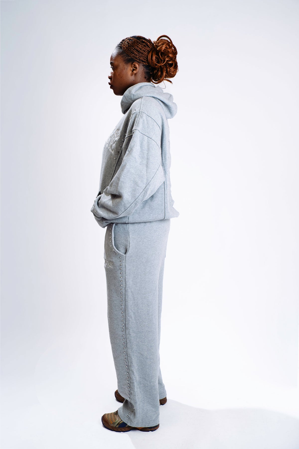Model wearing CHACHI Signature Hoodie in gray, side view